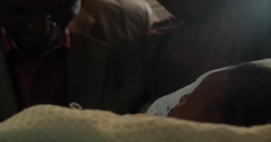 Man and woman admiring a baby that she's holding indoors