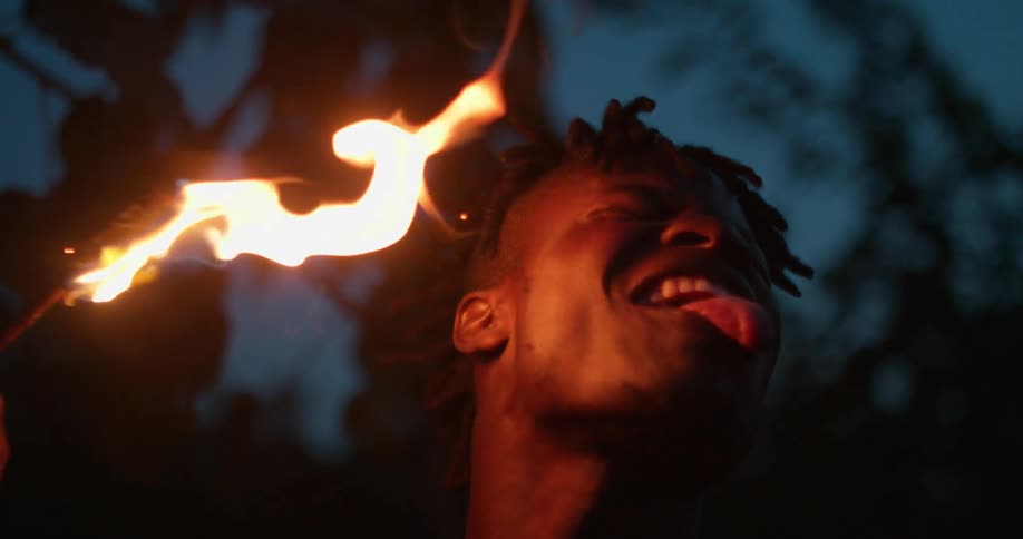 A man licks a lit torch