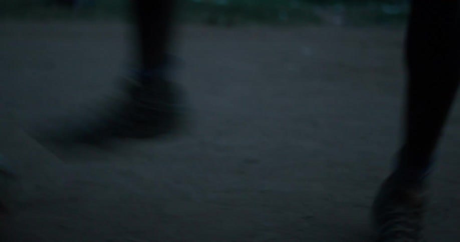 Person kicks a soccer ball outside at night