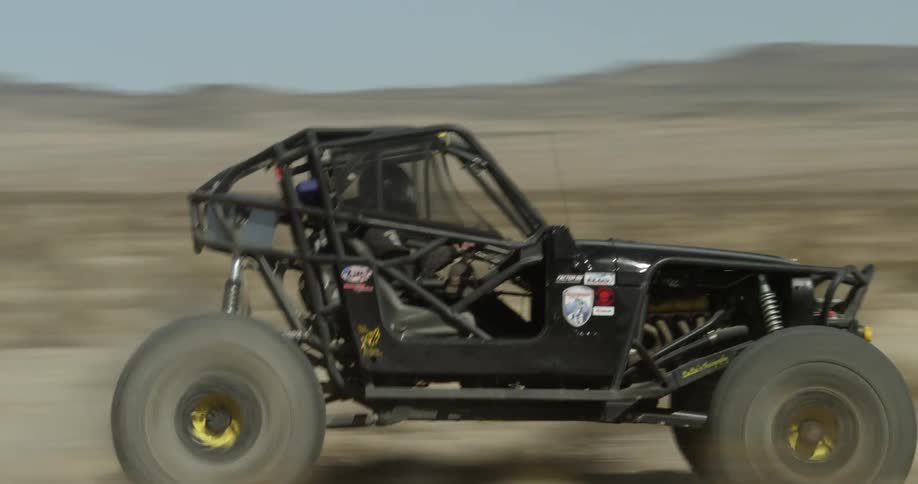 A dune buggy speeds through the desert