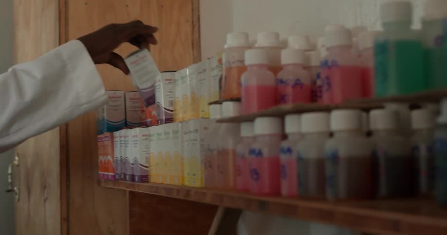 A doctor arranges boxes of medicine