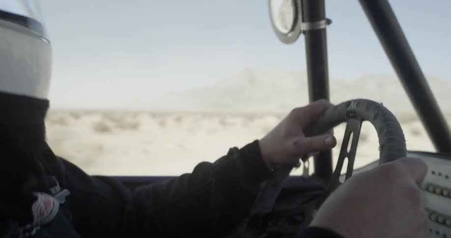 A person drives a dune buggy in the desert