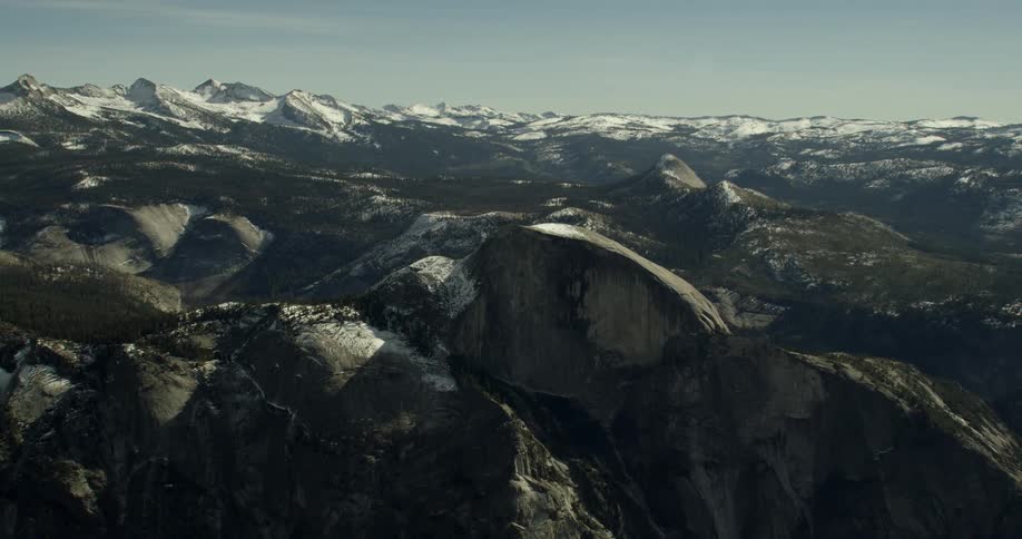 Rocky mountain peaks are dusted with snow near Half Dome in Yosemite National Park, California