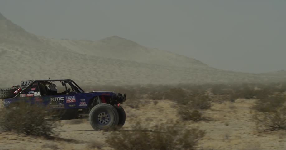 An off road vehicle travels through the desert