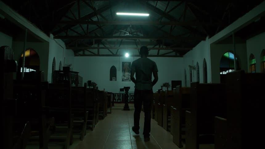A man walks down a church aisle