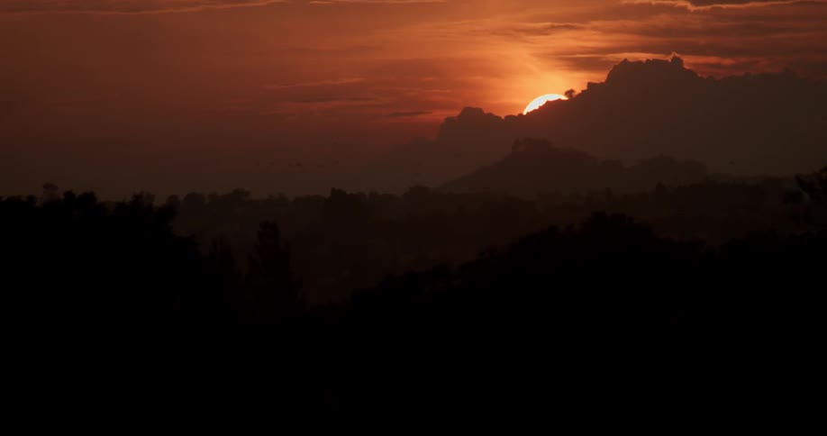 The sun is setting behind the mountain