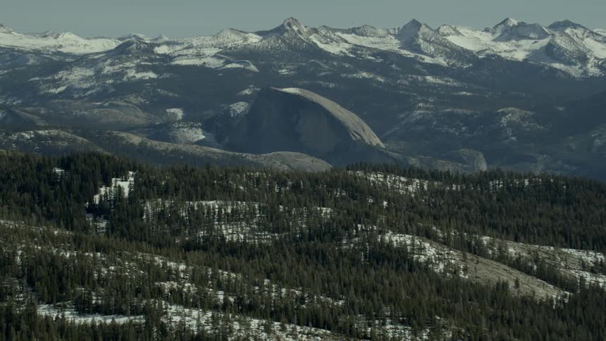 Green forest setting before Half Dome appears in Yosemite National Park, California