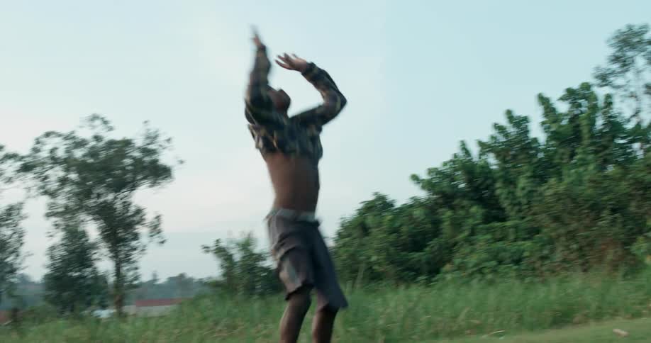 A young boy performs a cartwheel in the grass