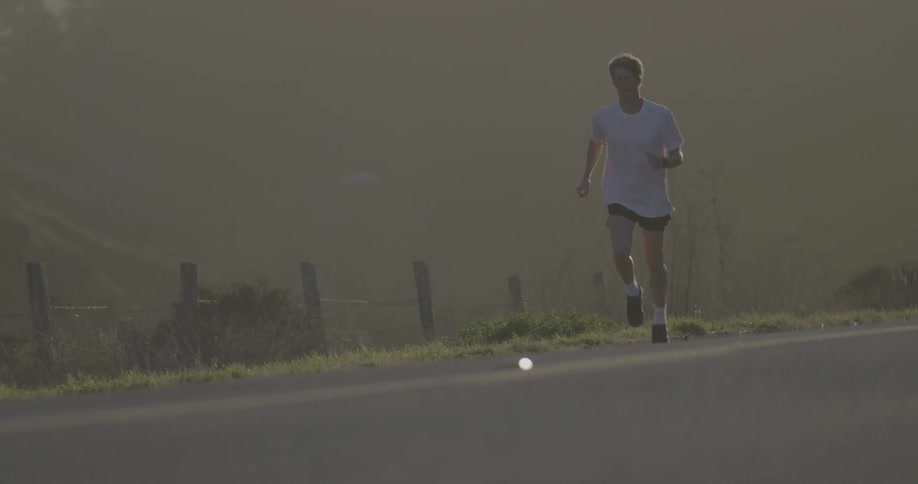 A young man jogs on a country road