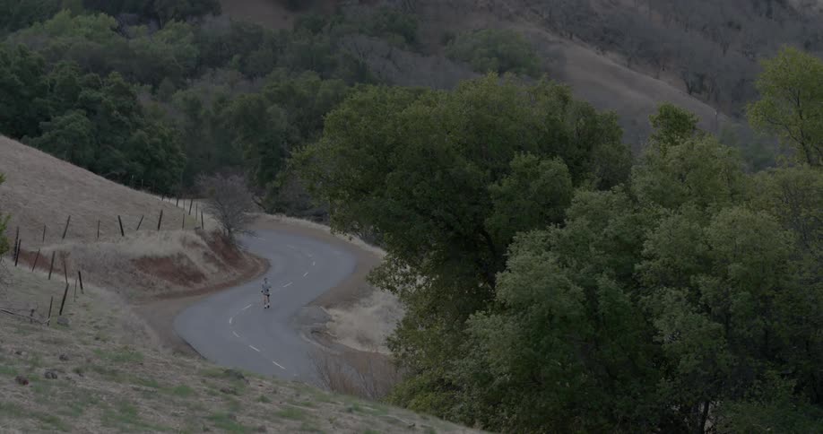 A man runs along a winding country road