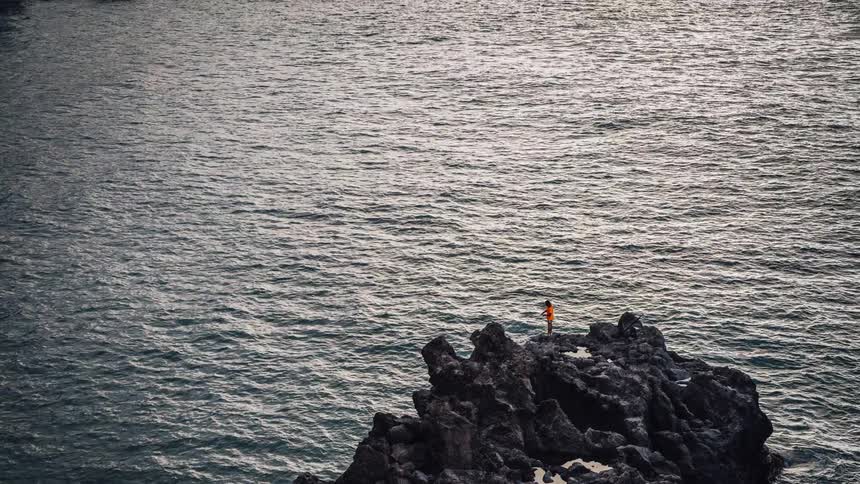 A jagged rock in a rippling body of water