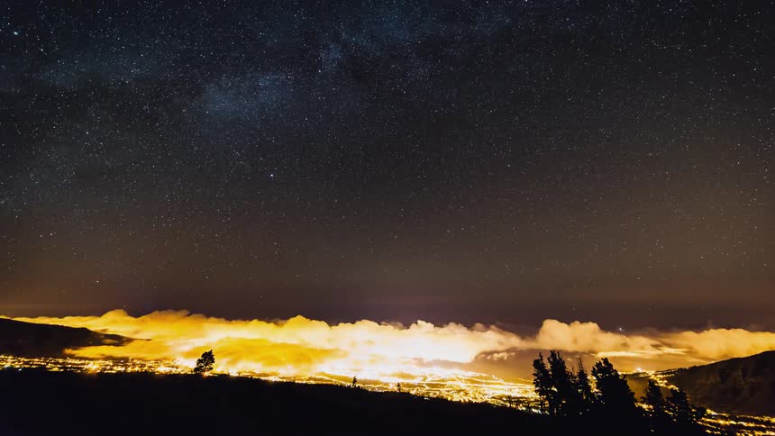 Clouds float in starry night sky
