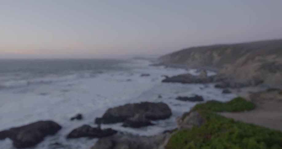 Ocean waves crash against the rocks on the shore