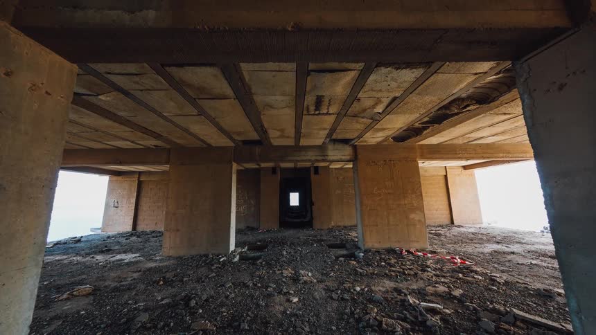 A gutted building floored with gravel