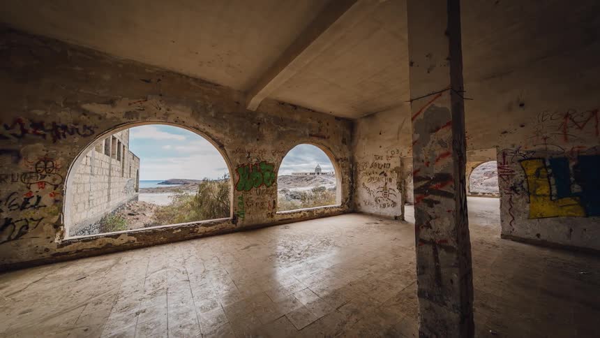 An abandoned stone building is being filmed