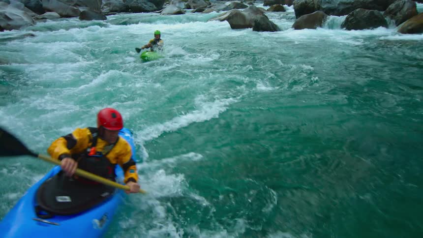 Kayaks are going over rapids