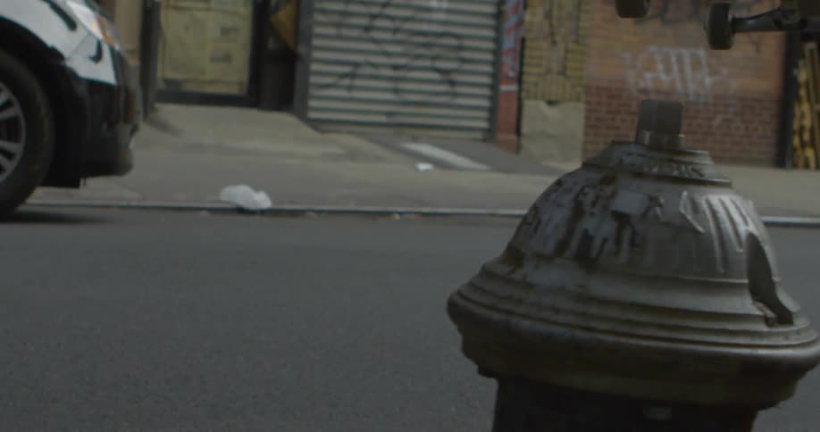 A skateboarder jumps over a fire hydrant in the city