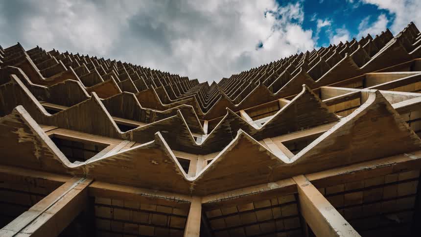 Clouds pass above a high rise structure during the day