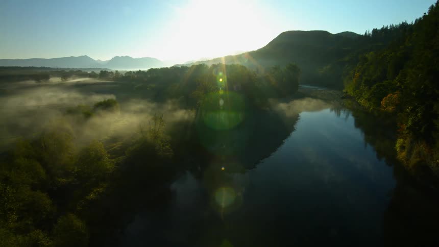 A drone flies over a fog covered field