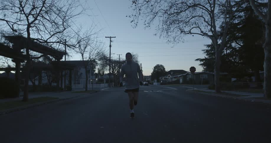 A man running in slow motion in the middle of a street