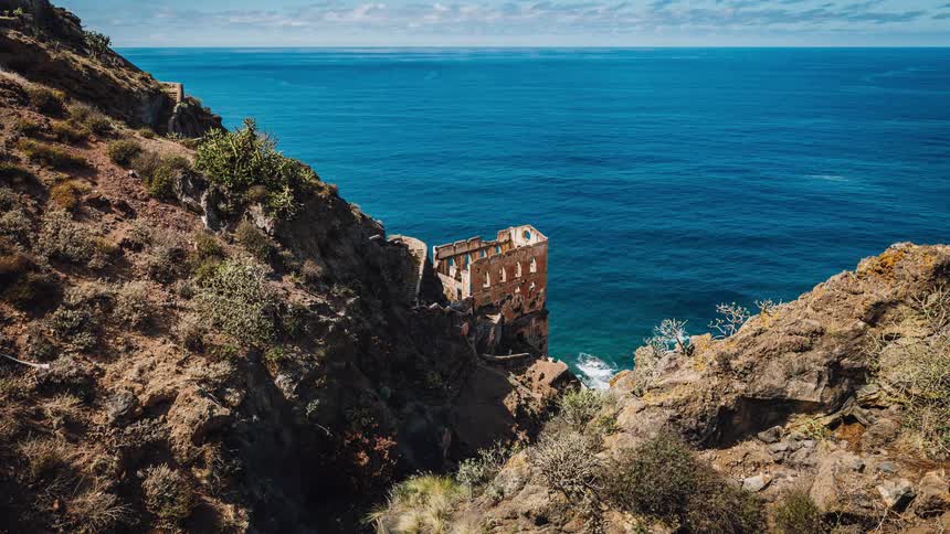 A decrepit building on a rocky cliff