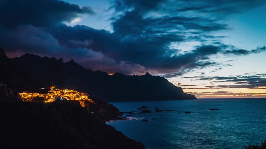 A timelapse of the sun sitting over a beach town