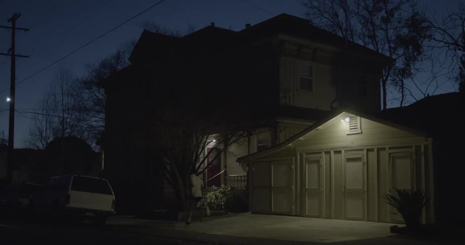 A person jogs past a house at night