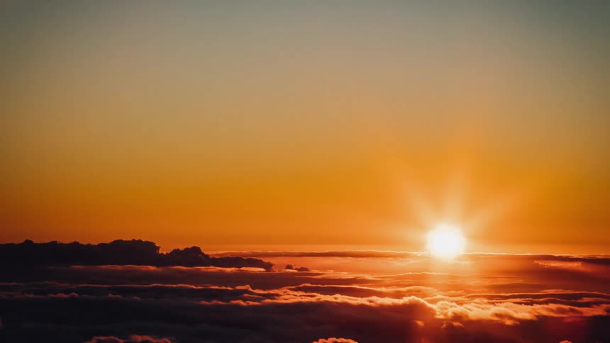 The sun shines above the flowing clouds