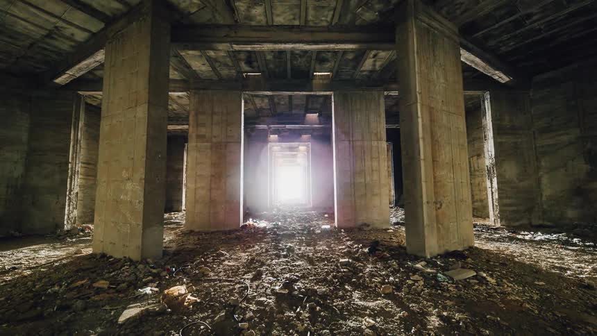 Pillars are surrounded by debris in an empty building