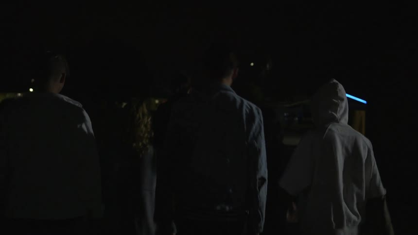 A group of people walking in front of flashing lights