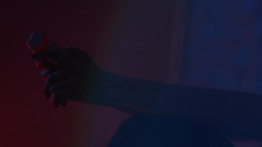 A pair of hands is holding a pill bottle