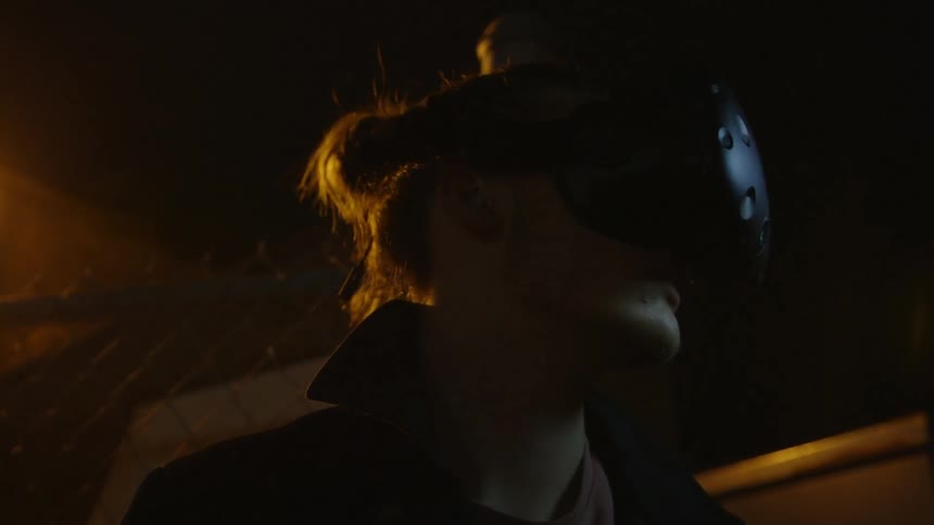 A man is outside at night using a virtual reality headset