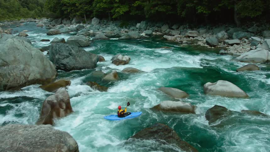 Two kayaks are traversing the rapids