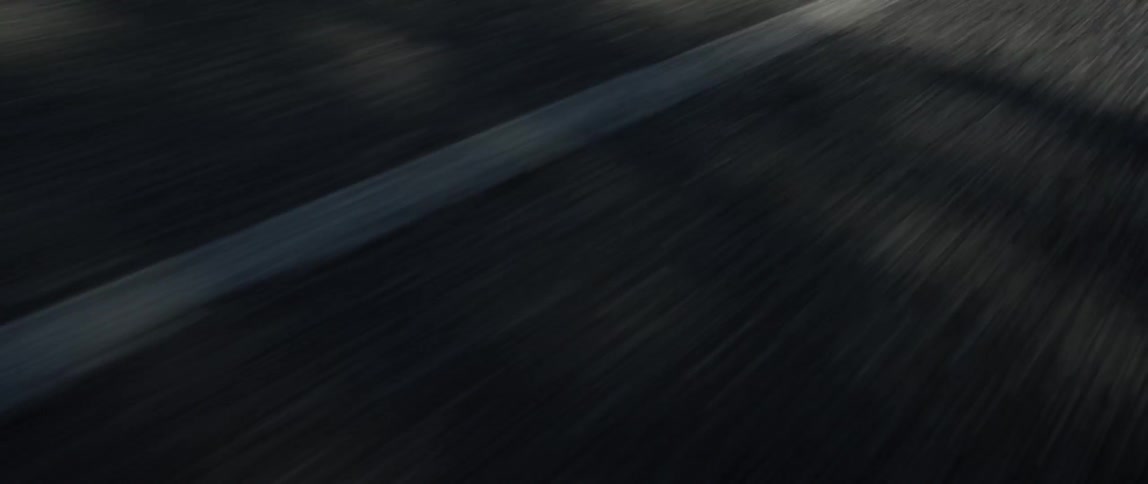 Asphalt with white road markers pass by