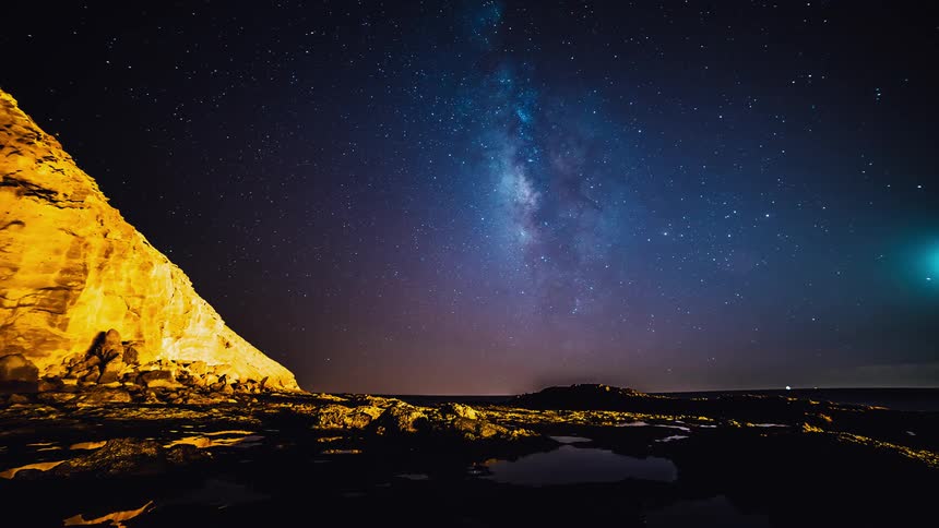 Water sits around the rocks as the sky darkens