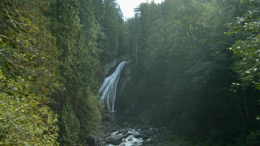 Waterfalls are being filmed by a drone in the woods