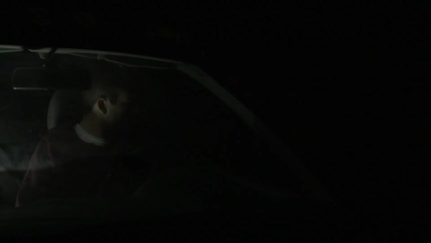 Someone is sitting in their car at night