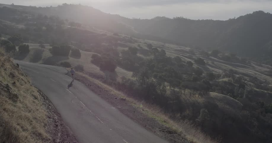 A young man jogging along the countryside road