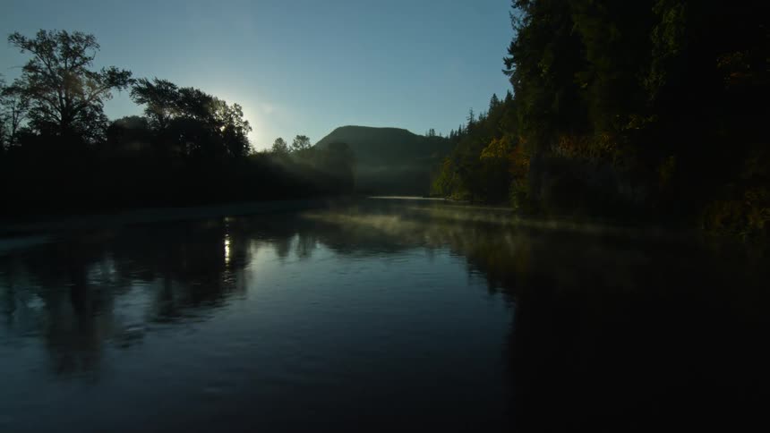 The sun casts rays on a river during the day