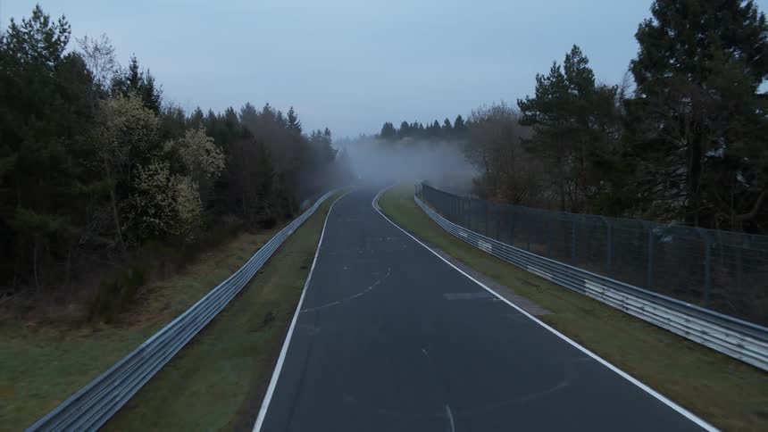 Fog drifts over a rural road during the day