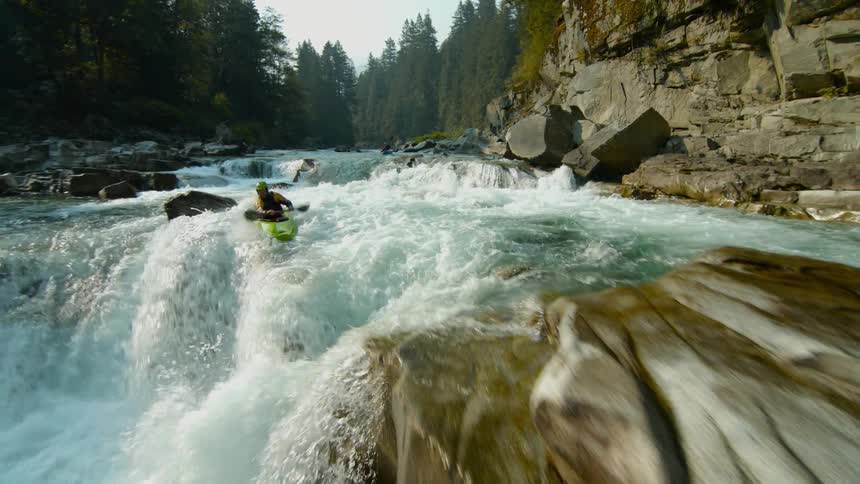 Someone kayaks down a choppy river
