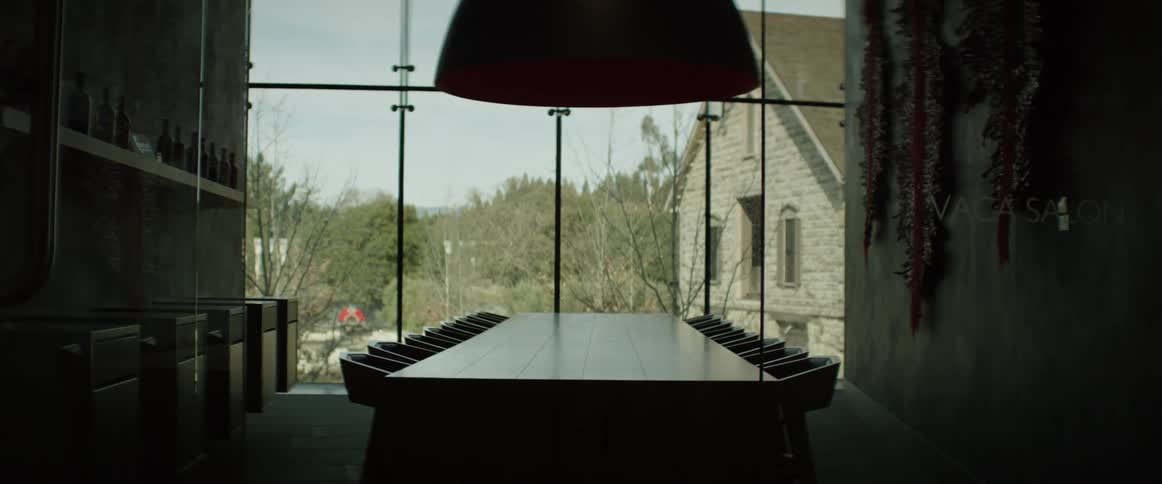 A conference table is sitting empty in front of a window