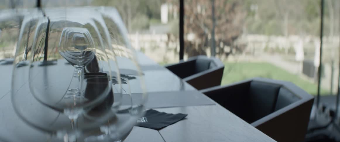 An empty chair and dining table are filmed