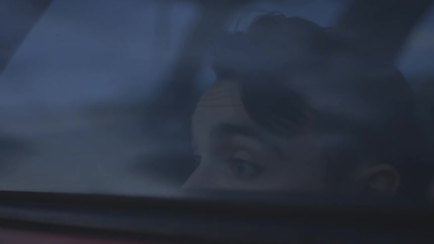 A person peeks over a car window
