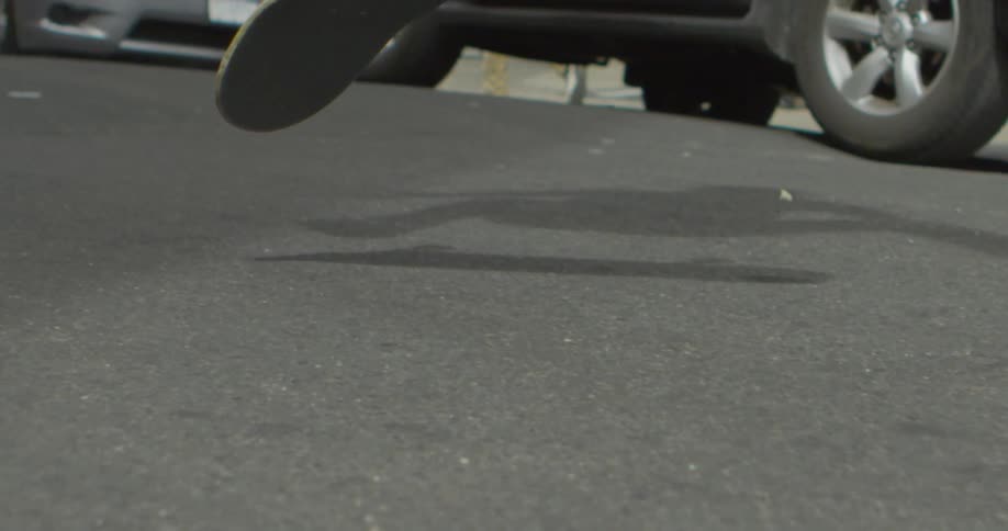 Someone is doing a skateboard trick in the middle of the street