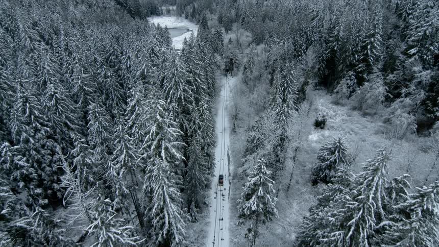 A drone films a car driving along a snow dirt road