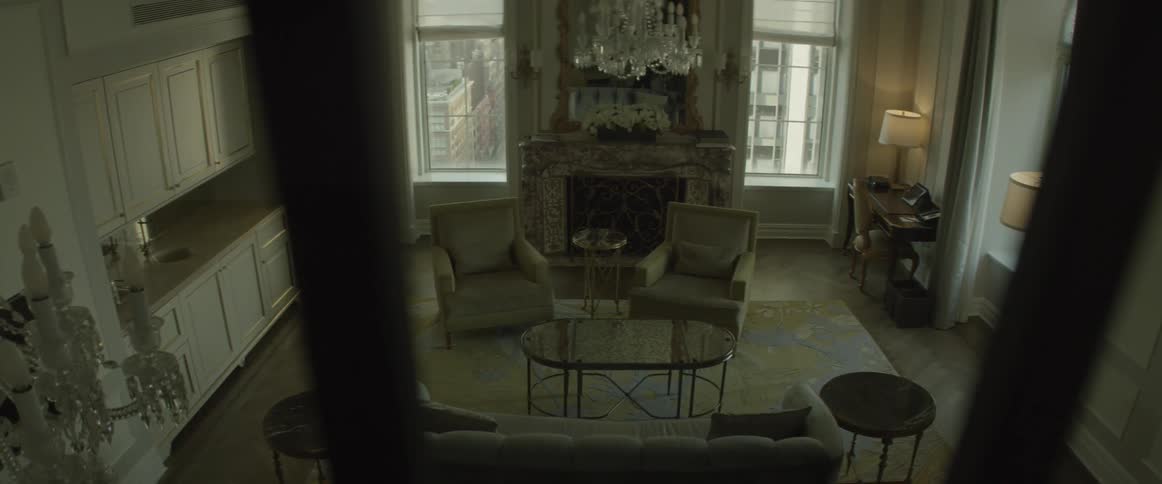 An empty living room is filmed from a staircase