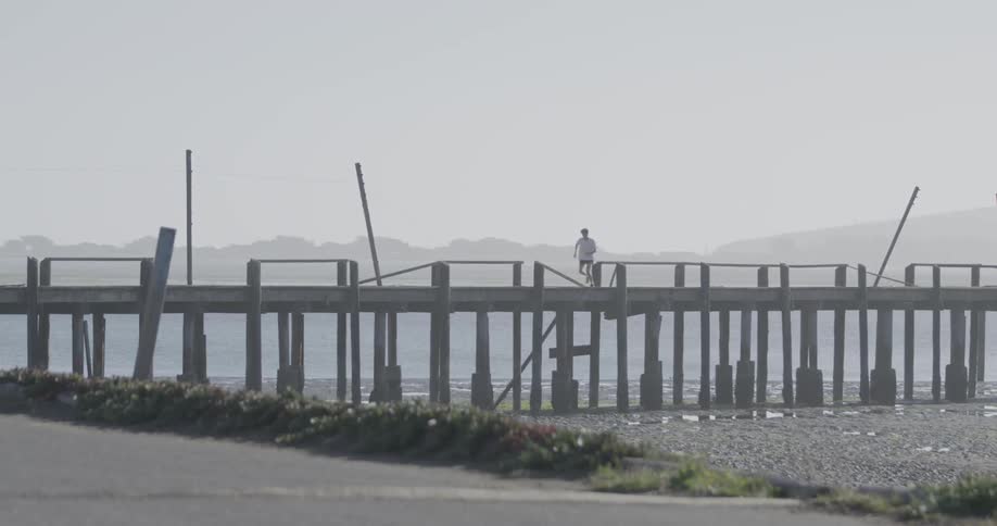 A man jogging on the bridge on a fine sunny day