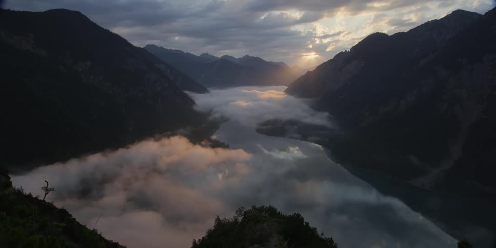 A foggy valley is filmed from a mountain