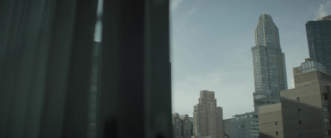 The city skyline is filmed from a window